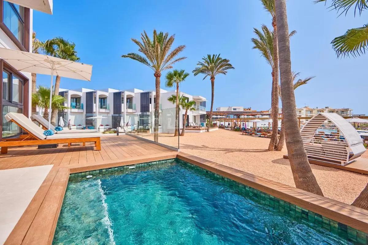 Área exterior moderna con piscina, tumbonas y pérgolas en complejo residencial de Mallorca