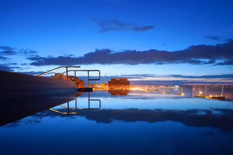 Atardecer urbano en Mallorca con reflejos en piscina y luces cálidas de la ciudad al anochecer