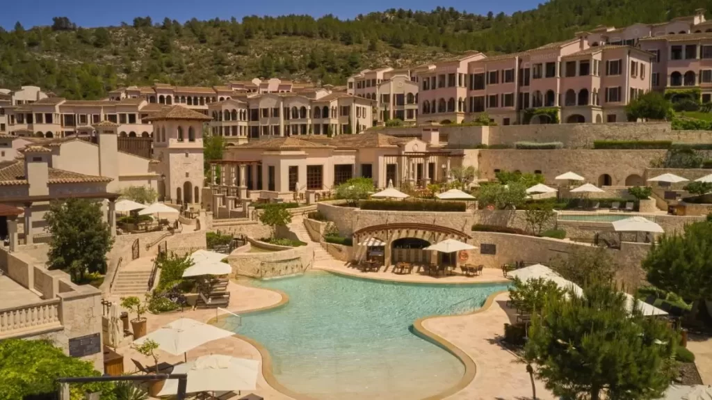 Complejo residencial mediterráneo en Mallorca con piscina irregular, terrazas y áreas de descanso al aire libre