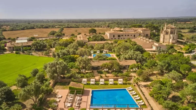 Complejo residencial rural en Mallorca con piscinas, camas balinesas y arquitectura tradicional en entorno campestre