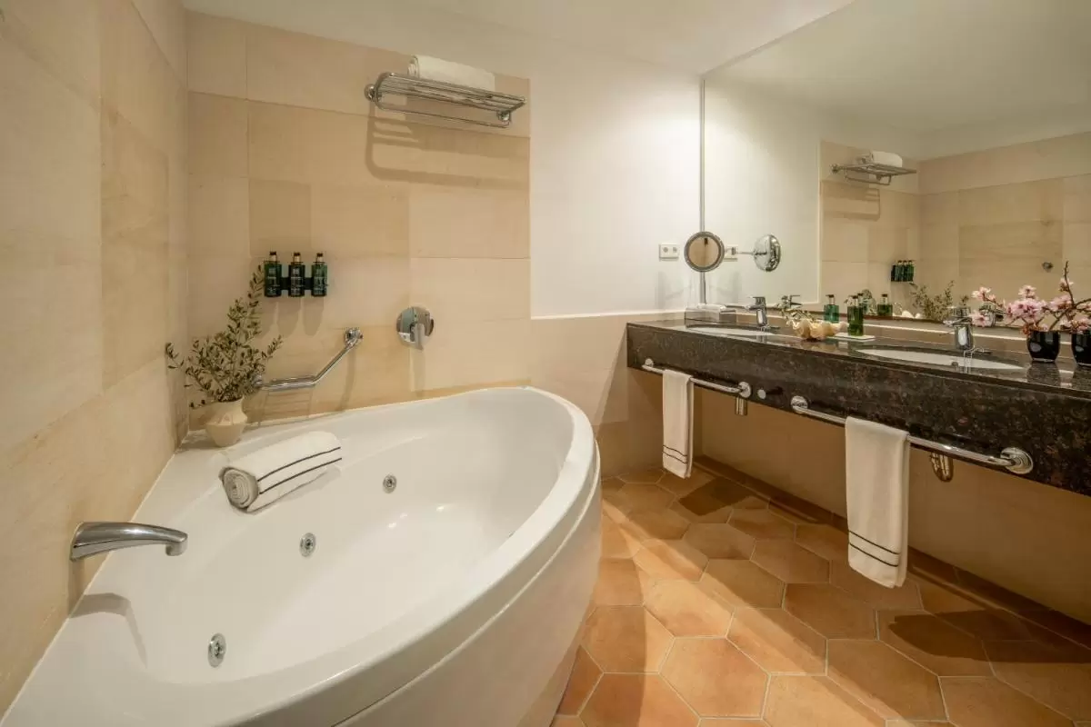 Melia Cala d'Or Boutique Hotel Diseño elegante de baño con bañera de hidromasaje ovalada, lavabos dobles y detalles en Mallorca
