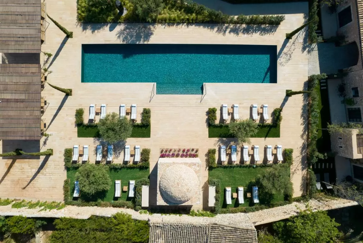 Diseño exterior con piscina rectangular, tumbonas con cojines y estructura circular en Mallorca