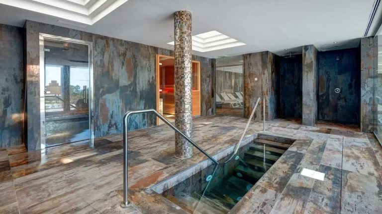 Diseño interior de espacio de bienestar con piscina, sauna, ducha y zona de relajación en Mallorca