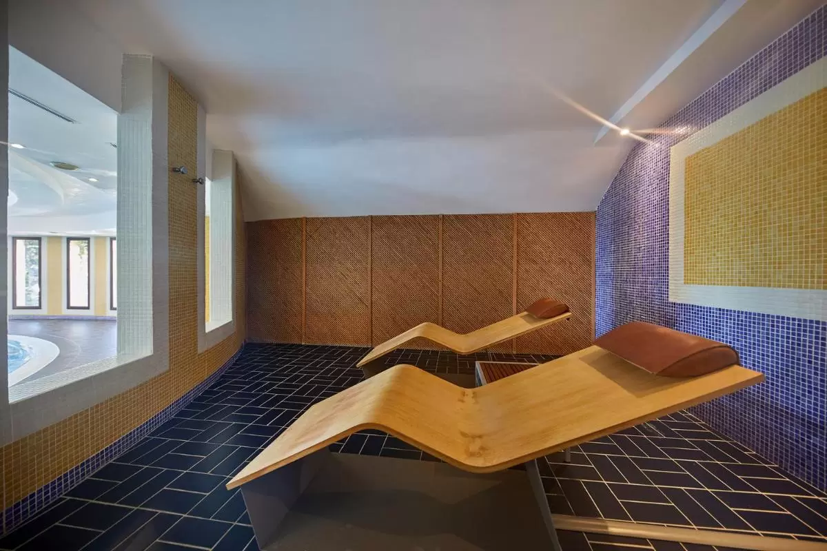 Diseño interior moderno para zonas de descanso en spa con tumbonas de madera y detalles en mosaico en Mallorca