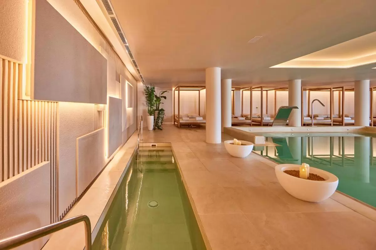 Diseño minimalista y relajante de piscina cubierta con jacuzzis y áreas de descanso en Mallorca