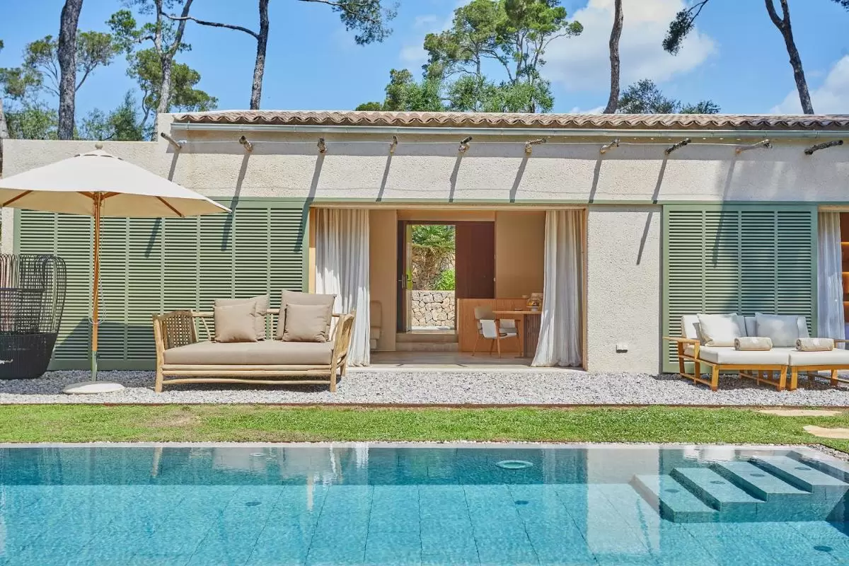 Diseño moderno de piscina y área exterior con mobiliario de jardín en vivienda de una planta en Mallorca
