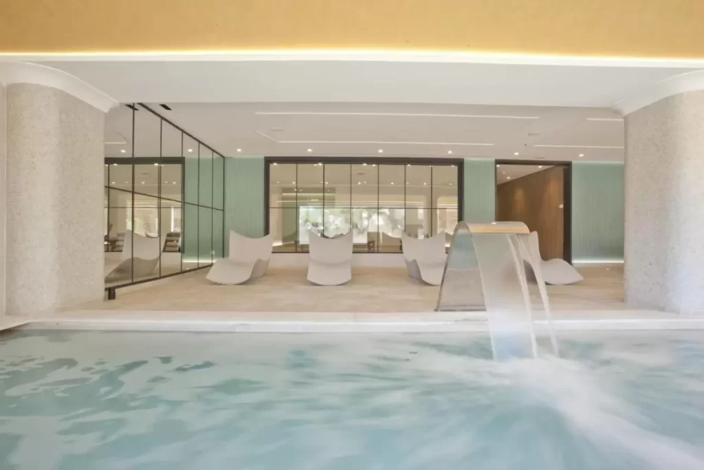 Diseño moderno y minimalista de piscina interior con jacuzzi y zona de descanso ergonómica en Mallorca
