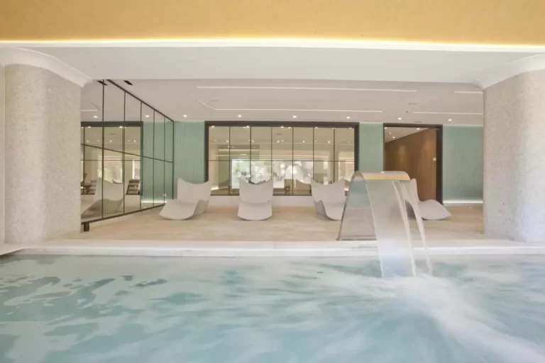 Diseño moderno y minimalista de piscina interior con jacuzzi y zona de descanso ergonómica en Mallorca