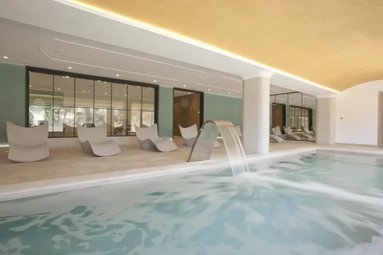 Espacio interior con piscina de spa, sillas reclinables modernas y techo abovedado iluminado en Mallorca