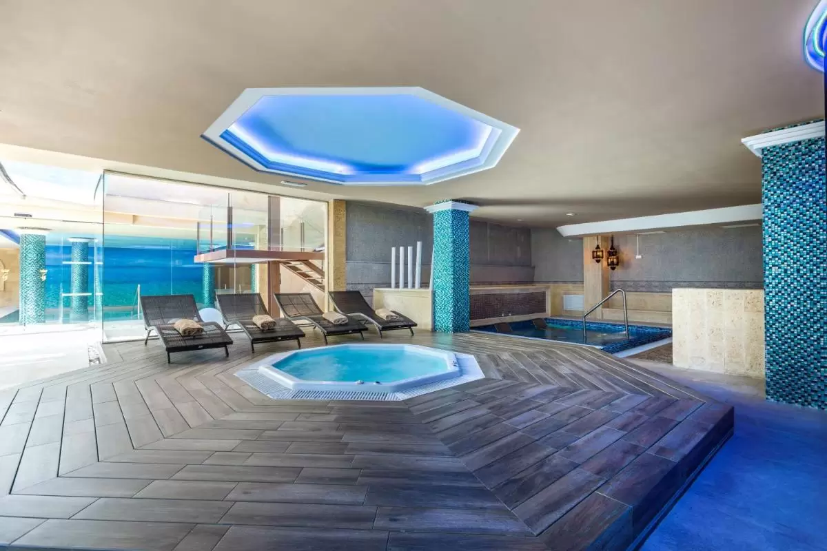 Espacio interior de relajación con jacuzzi octagonal y piscina en entorno luminoso y moderno en Mallorca