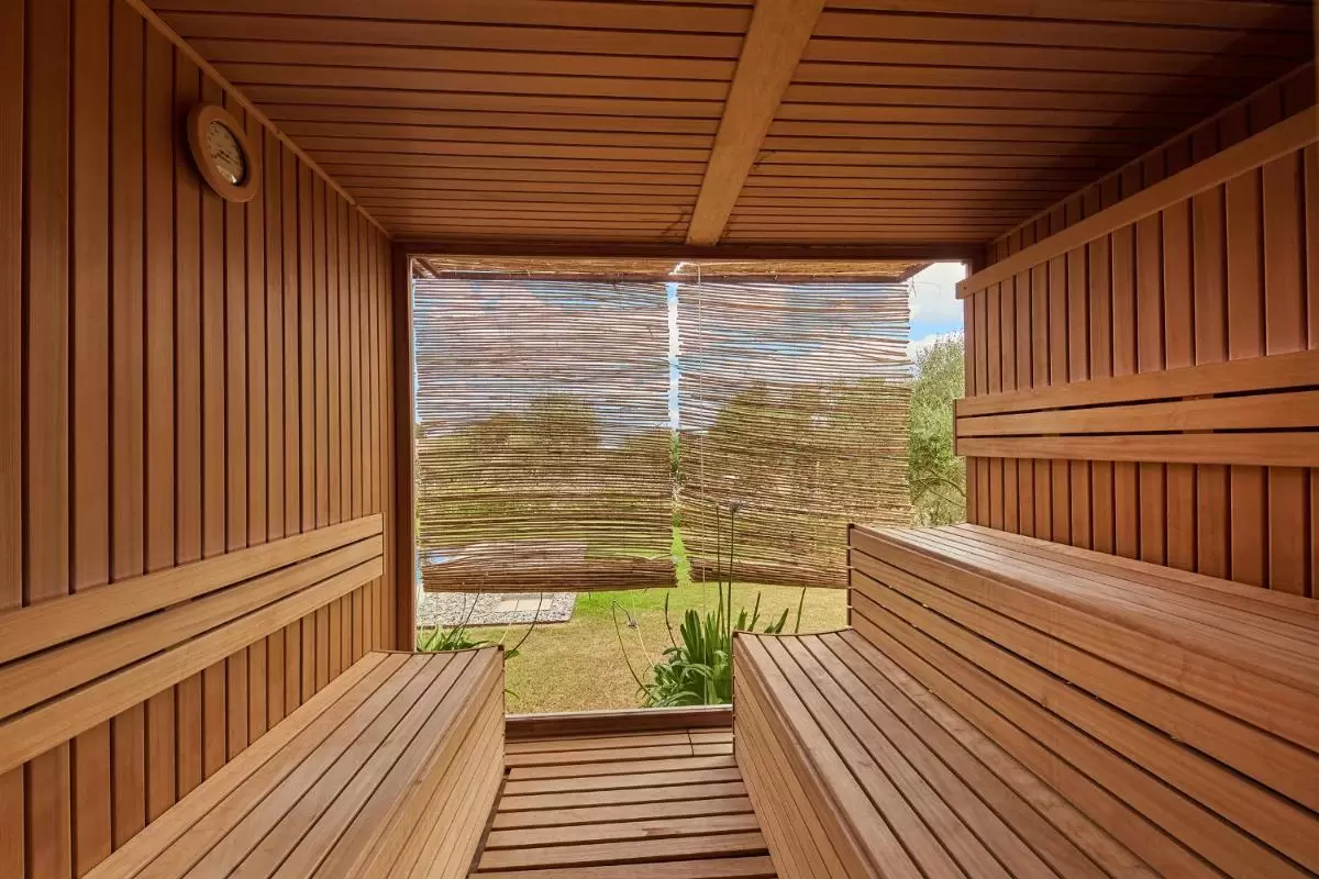 Grand Luxury Hotel by Nature - Adults Only Interior de sauna de madera natural con bancos en dos niveles y vista exterior a zona verde en Mallorca