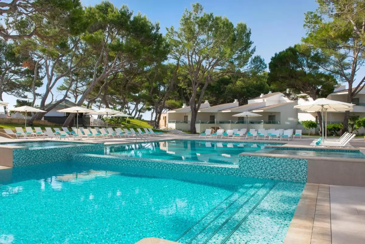 Piscina al aire libre con diseño en dos niveles y revestimiento de mosaicos azul turquesa en Mallorca
