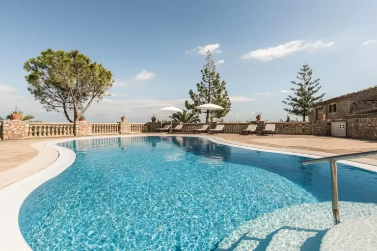 Piscina al aire libre con diseño irregular, escalones semicirculares y entorno natural en Mallorca
