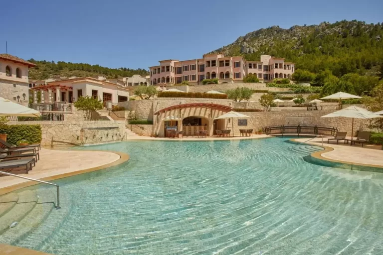 Piscina al aire libre con diseño irregular y entorno natural en Mallorca con zona de descanso y vegetación
