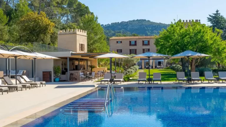 Piscina al aire libre con tumbonas, área de descanso y jardín en entorno natural en Mallorca