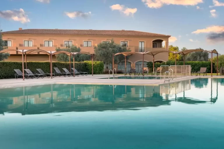 Piscina al aire libre con tumbonas y toldos en espacio exterior tranquilo y sombreado en Mallorca