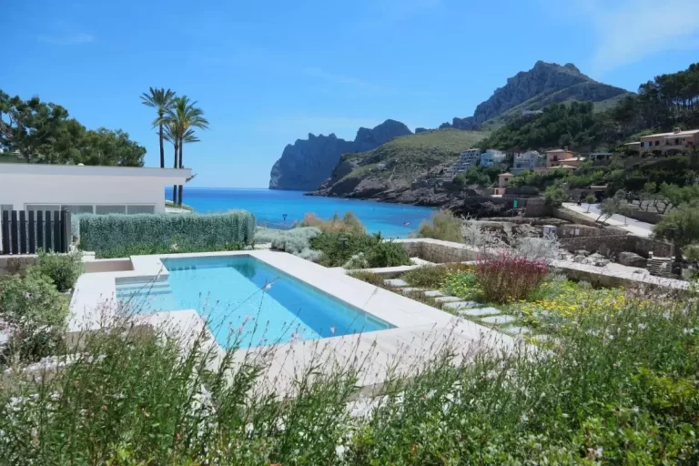 Piscina al aire libre con vistas al mar y entorno natural en zona costera de Mallorca con vegetación y arquitectura moderna