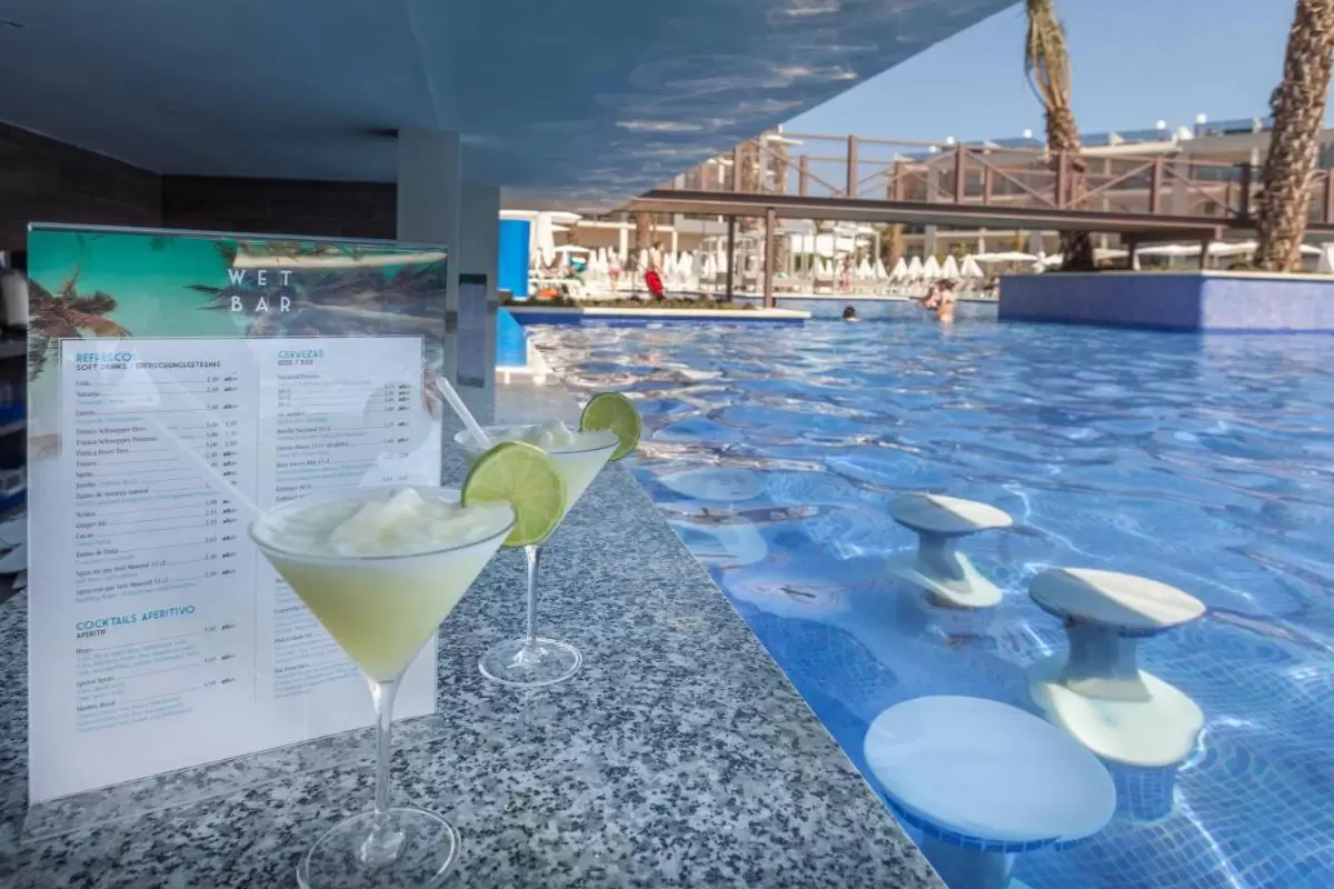 Piscina al aire libre con wet bar integrado y área de descanso con tumbonas y sombrillas en Mallorca