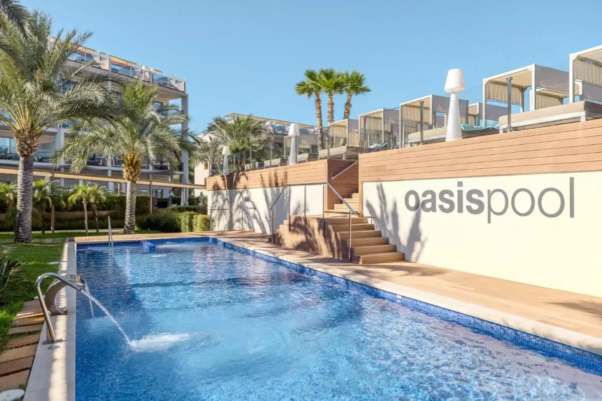 Piscina al aire libre en Mallorca con estructura de varios niveles y camastros con toldos blancos