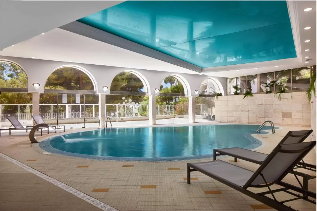Hilton Mallorca Galatzo Piscina cubierta con diseño moderno, iluminación natural y detalles en vegetación en Mallorca