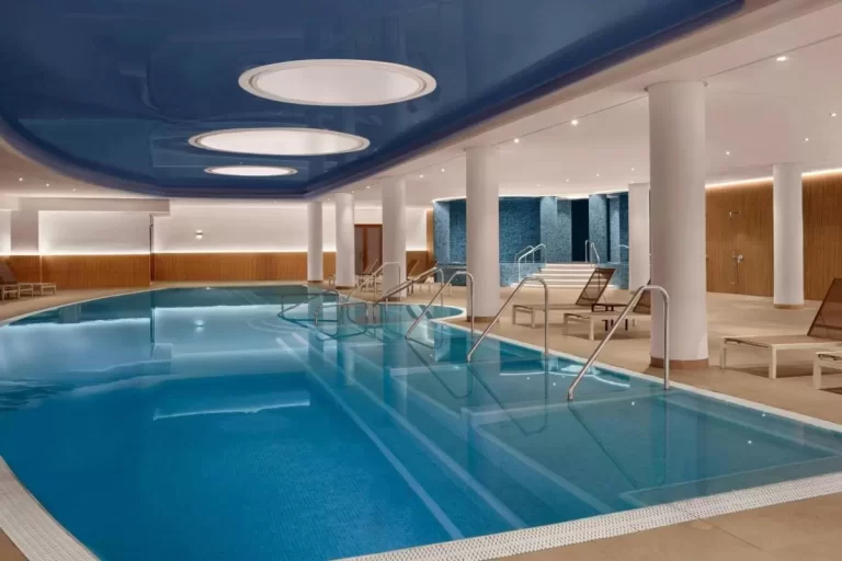 Piscina cubierta moderna con jacuzzi y área de descanso en espacio cerrado con iluminación suave en Mallorca