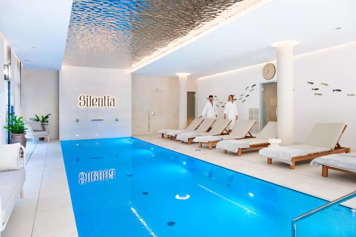 Piscina interior con camastros, ducha y decoración marina en ambiente relajante y luminoso en Mallorca