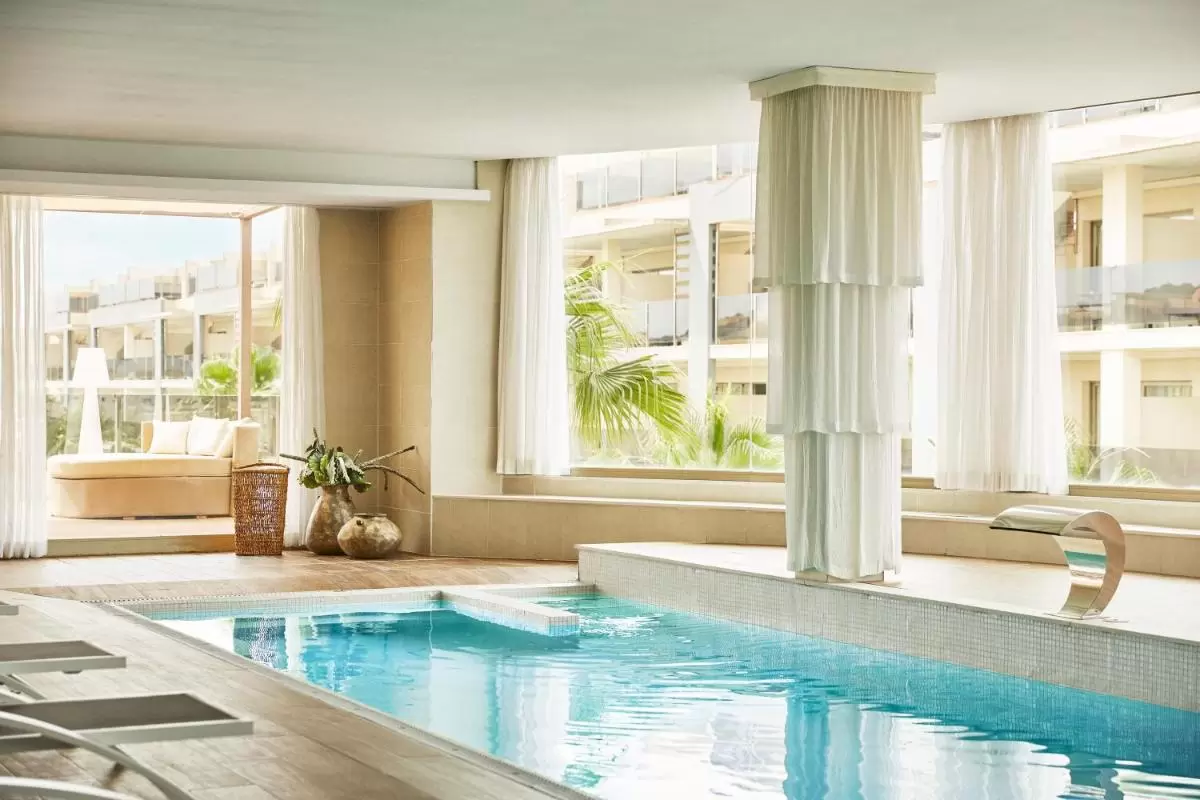 Piscina interior con jacuzzi y diseño relajante en espacio luminoso con vistas a Mallorca