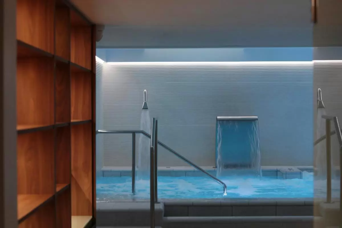 Piscina interior moderna con sistema de hidromasaje, cascada de agua y diseño minimalista en Mallorca