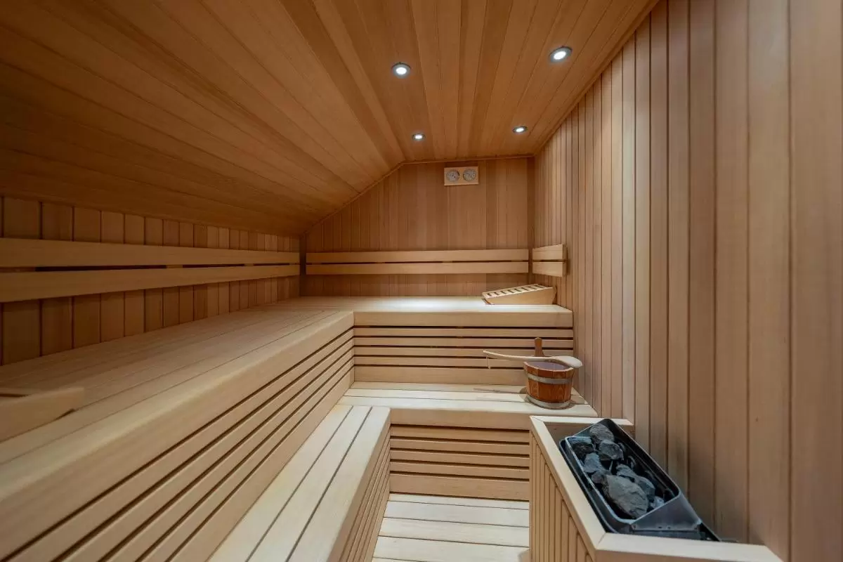 Palacio Ca Sa Galesa Sauna de madera clara con bancos en dos niveles, iluminación empotrada y calentador eléctrico en Mallorca