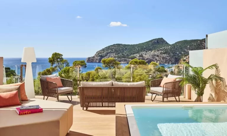 Terraza al aire libre con piscina y mobiliario moderno con vistas panorámicas al mar y montañas en Mallorca