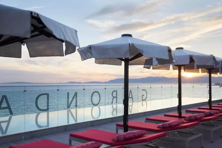 Terraza al aire libre con tumbonas y piscina frente al mar en Mallorca durante el atardecer
