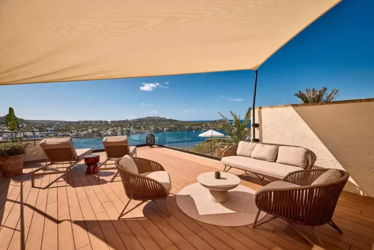 Terraza amplia en Mallorca con muebles de exterior, vistas al lago, tumbonas y sombra natural