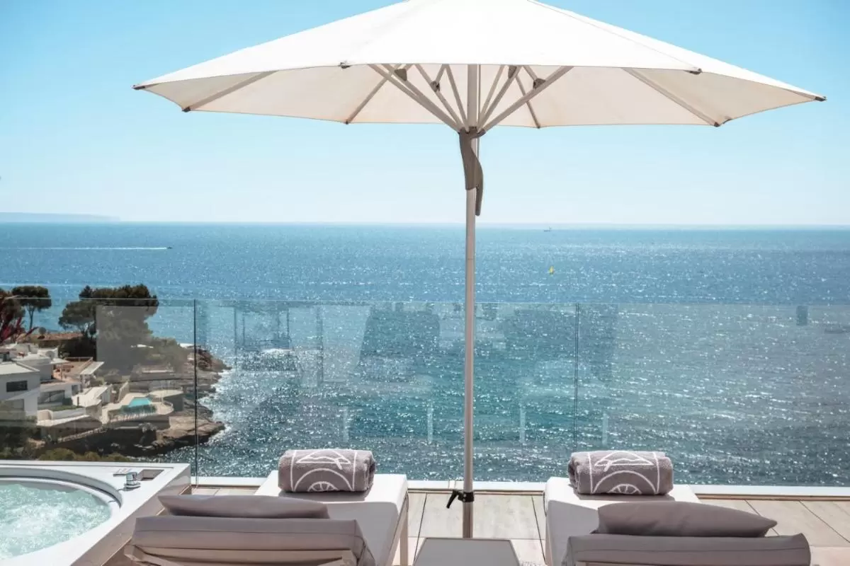Terraza con jacuzzi y tumbonas frente al mar en Mallorca con vistas despejadas y ambiente relajante