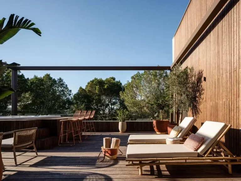 Terraza exterior contemporánea en Mallorca con jacuzzi empotrado, muebles de madera y detalles naturales