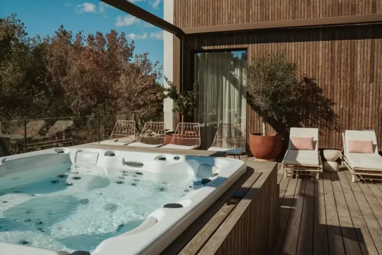 Terraza exterior en Mallorca con jacuzzi empotrado, mobiliario de madera y diseño contemporáneo para relajación al aire libre