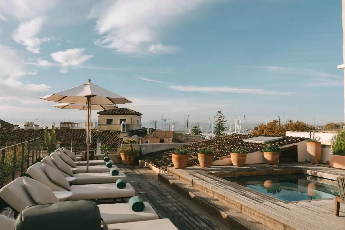 Terraza moderna con piscina y tumbonas junto al puerto en Mallorca con ambiente relajante y vistas al mar