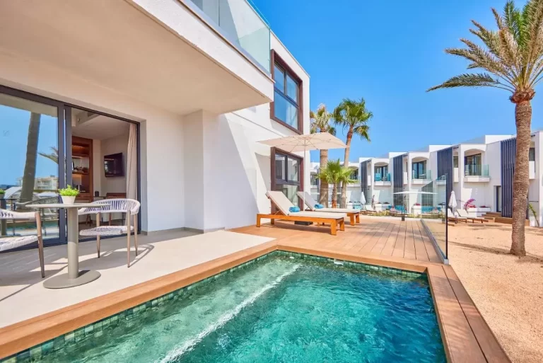 Terraza moderna en Mallorca con piscina rectangular, tumbonas y mobiliario contemporáneo en ambiente soleado