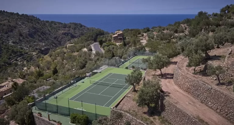 Vista aérea de canchas de tenis en Mallorca con paisaje montañoso y vistas al mar en entorno natural