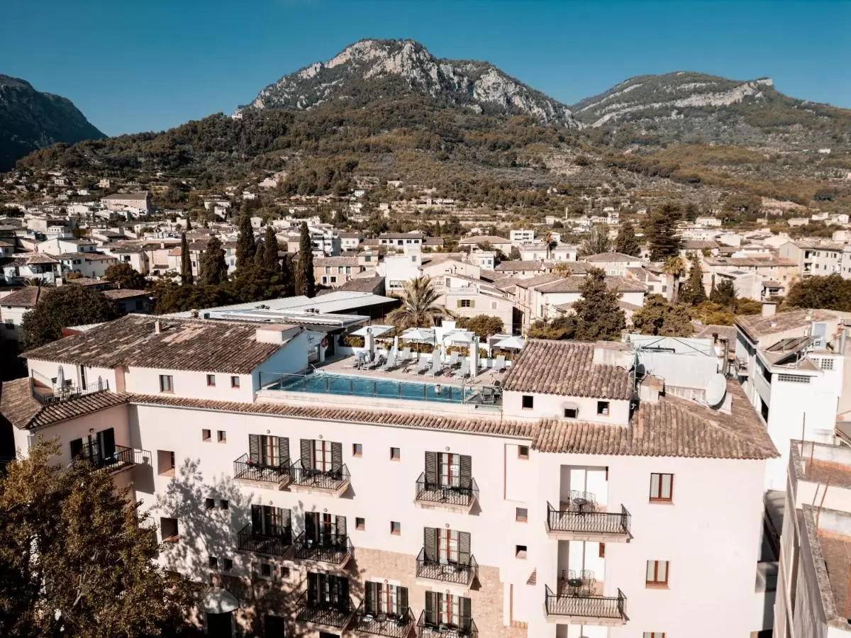 Vista panorámica de edificio residencial con piscina en azotea y paisaje montañoso en Mallorca