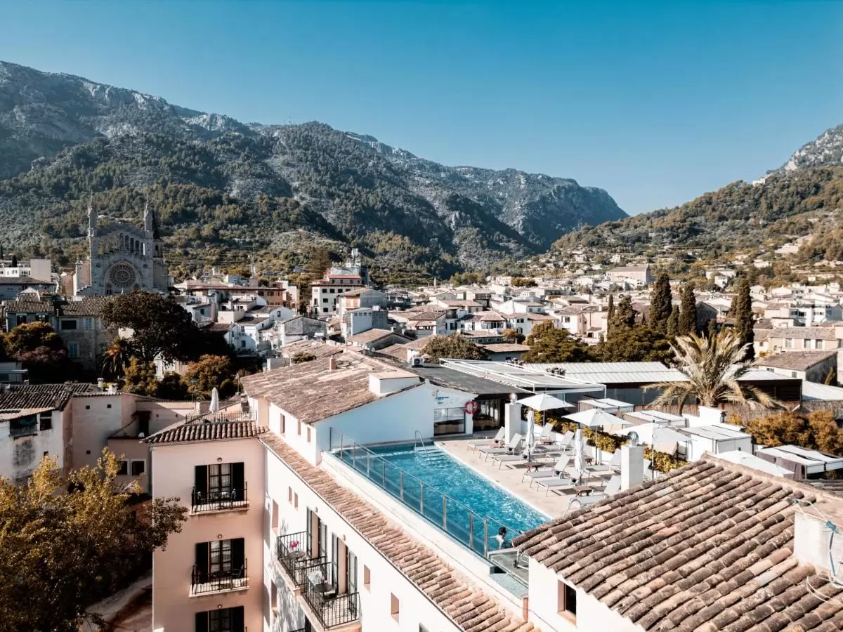 Vista panorámica de pueblo en Mallorca con piscina en azotea y paisaje montañoso mediterráneo