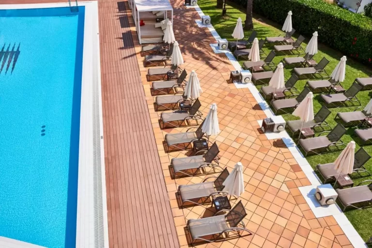 Zona exterior de piscina con tumbonas, sombrillas y área de descanso en Mallorca con iluminación natural